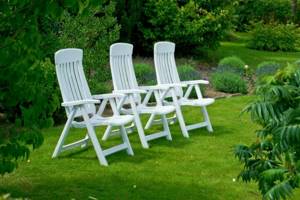 White garden chairs on the park lawn