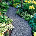 Winding path in the garden limited by plastic guides