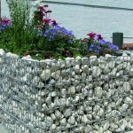 Flower bed made of stones in a steel mesh