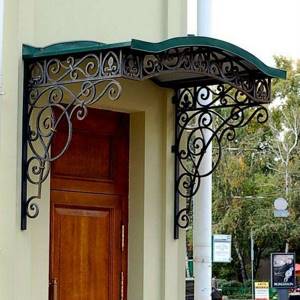 Beautiful openwork canopy made of forging over the porch