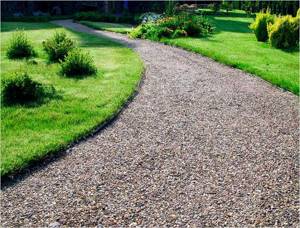 The main path made of crushed stone is wide; by moving it to the side, the space visually expands