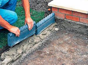 Installing curbs for a walkway on a cement pad