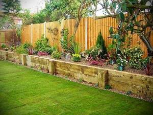 A high flower bed with a fence made of boards. Construction will be inexpensive, and the appearance will be solid 